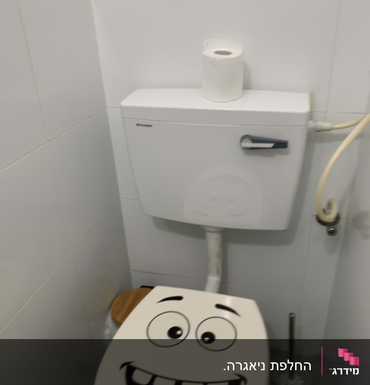 אסלה עם מדבקה מצוירת, מברשת ניקוי ושירותים